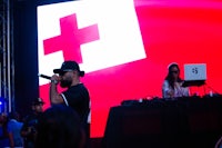 a man on a stage with a red and white flag behind him